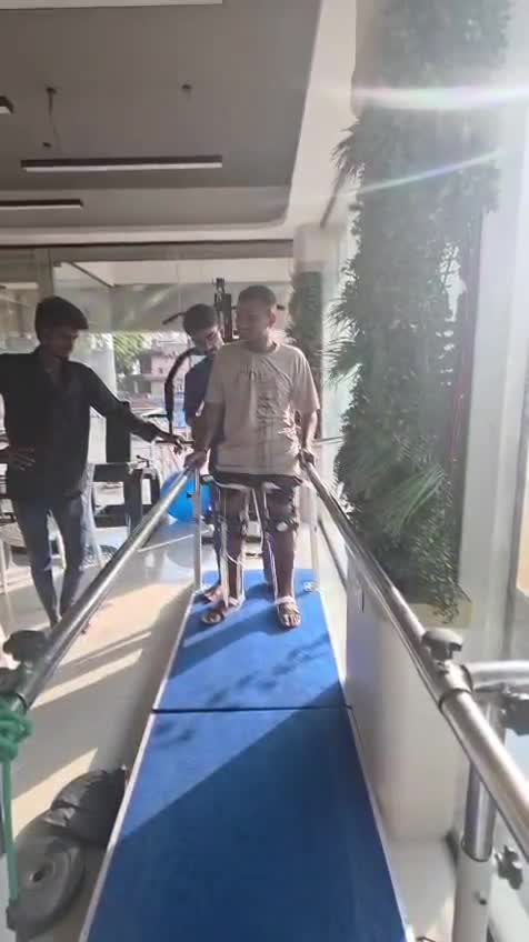Patient walking with robotic leg supports and parallel bars